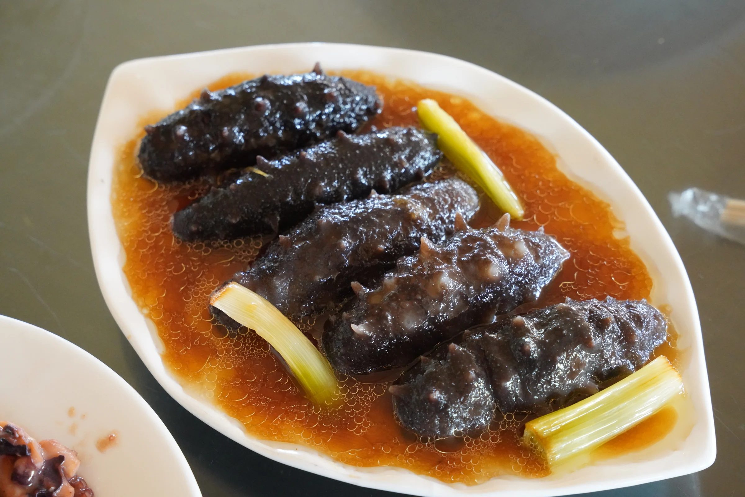 整齐摆放的海参菜肴与金色酱汁